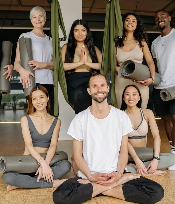 Diverse group of people smiling during a yoga class.
